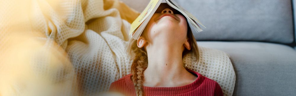 Ein kleines Kind albert mit einem Taschenbuch aus dem Verlag Egmont Publishing herum